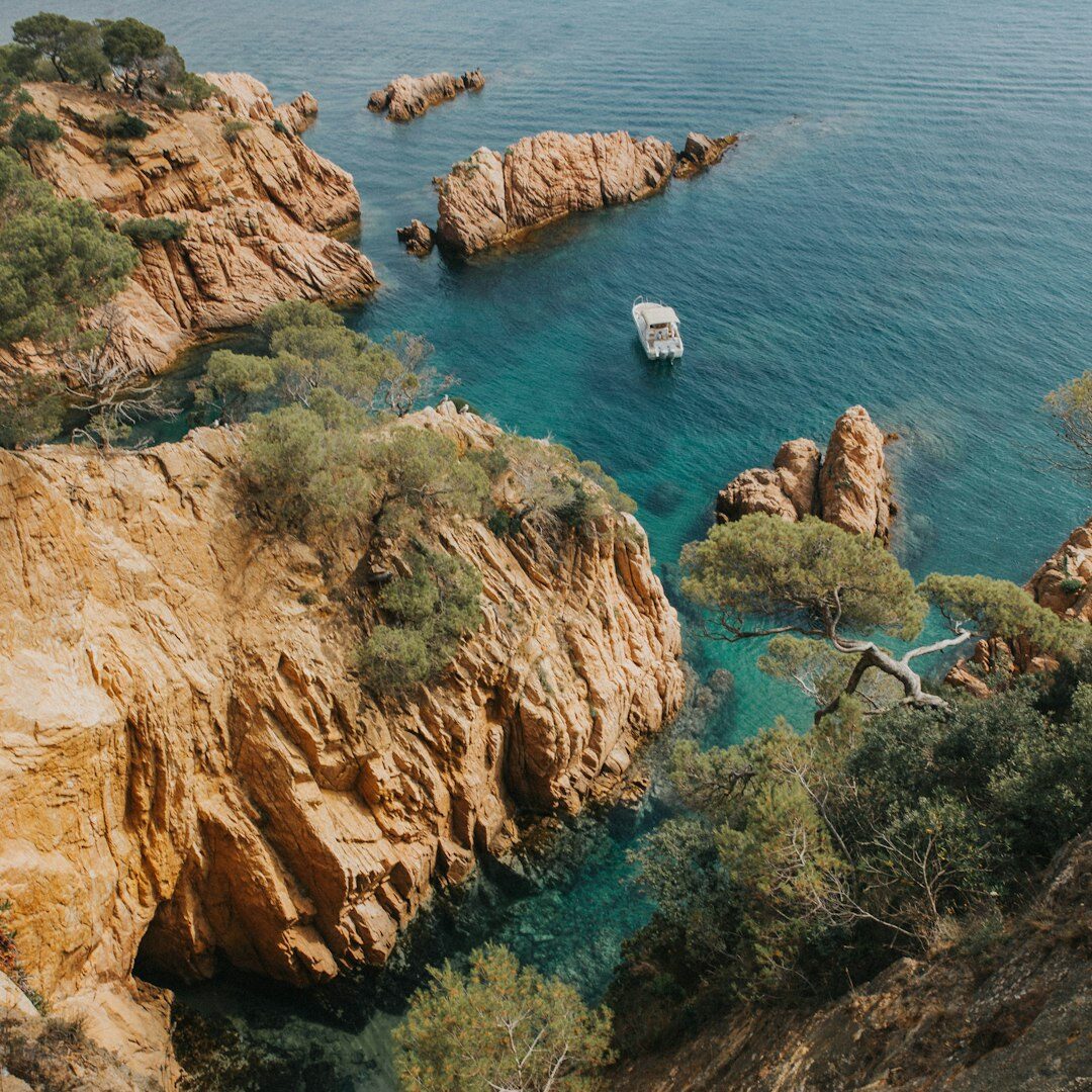 bird's-eye photography of boat near rock formations